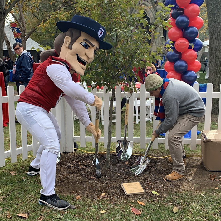 Penn student Nhieu is planting the Class of 2023 tree with the Penn Quaker.