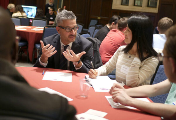 John Gamba talking at a table of people