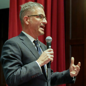 John Gamba, Jr. speaking into a microphone