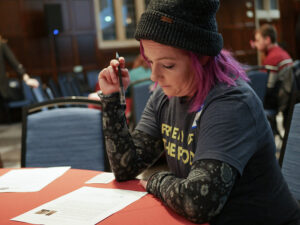 Girl wearing hat at a table writing