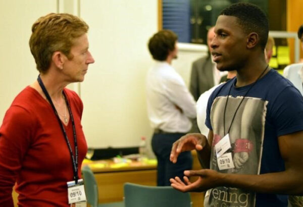 Woman talks to man at a conference