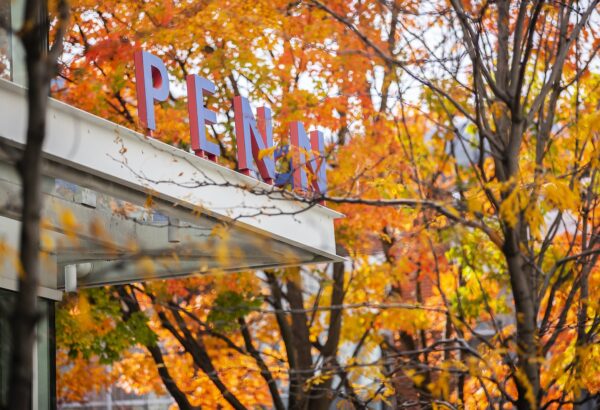 Building with Penn sign in the midst of autumn scenery