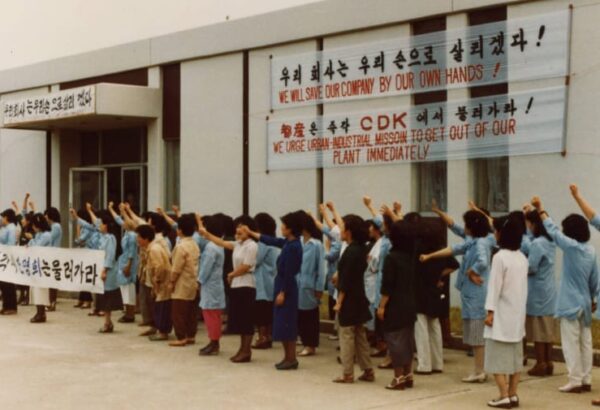 Several people protesting outside of a building