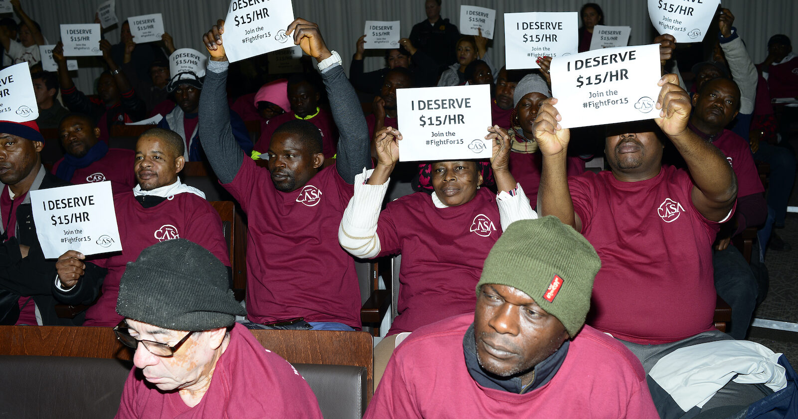 Protestors hold up $15 minimum wage signs