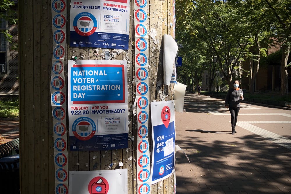 A pillar on Penn's campus covered with flyers urging people to vote
