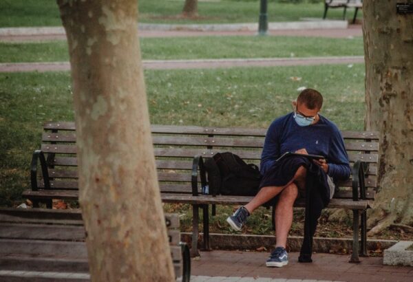 Student studying outside while wearing a mask