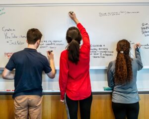 Students writing on a whiteboard