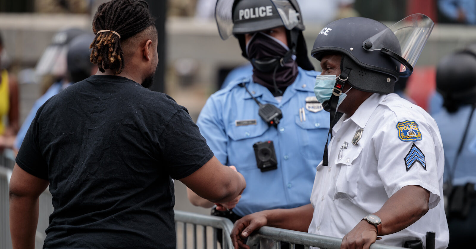 Protestor shaking hands with police officer