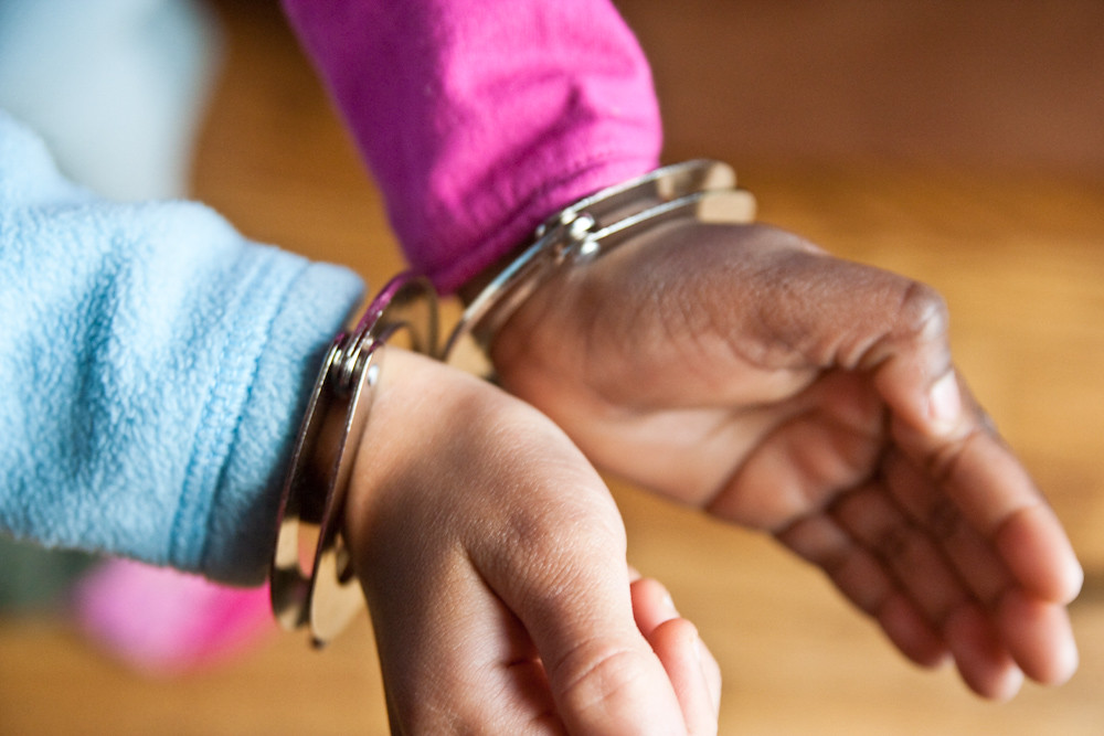 Young persons hands in handcuffs.