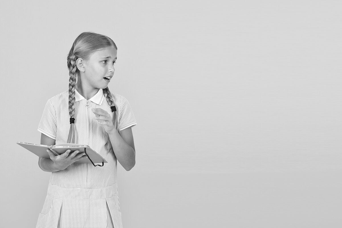 black and white photo of a girl holding book