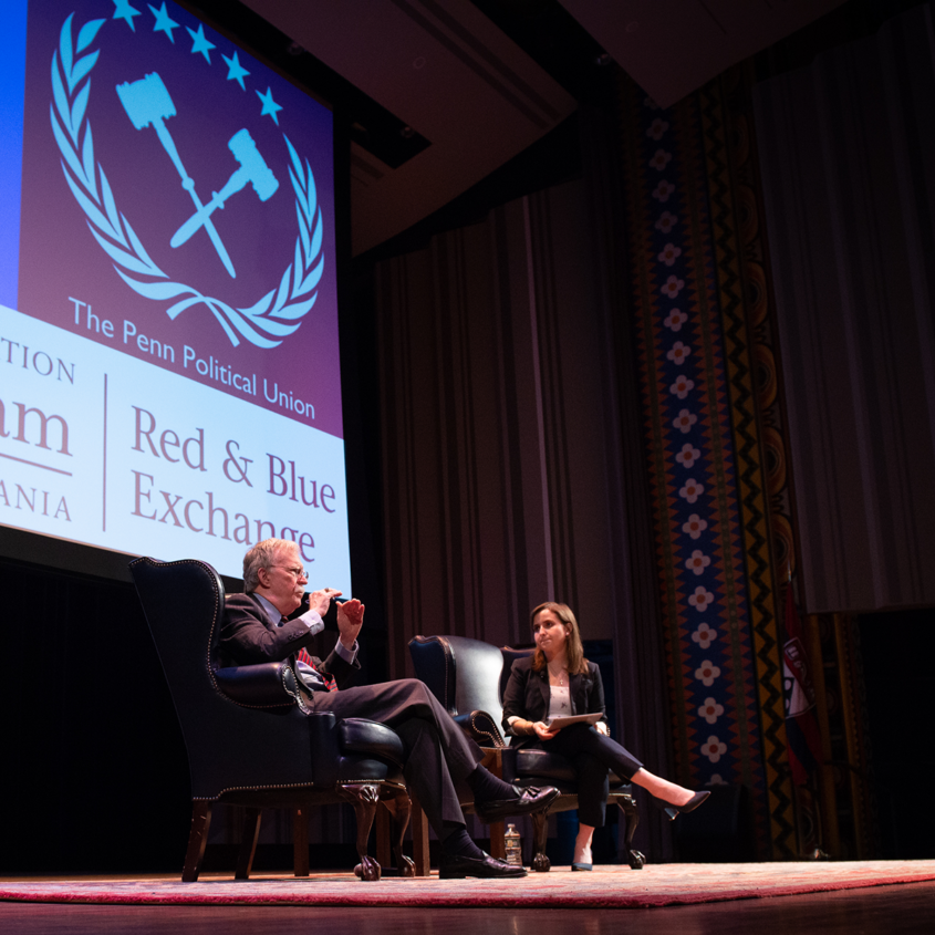 photo of John Bolton on stage with student at Penn