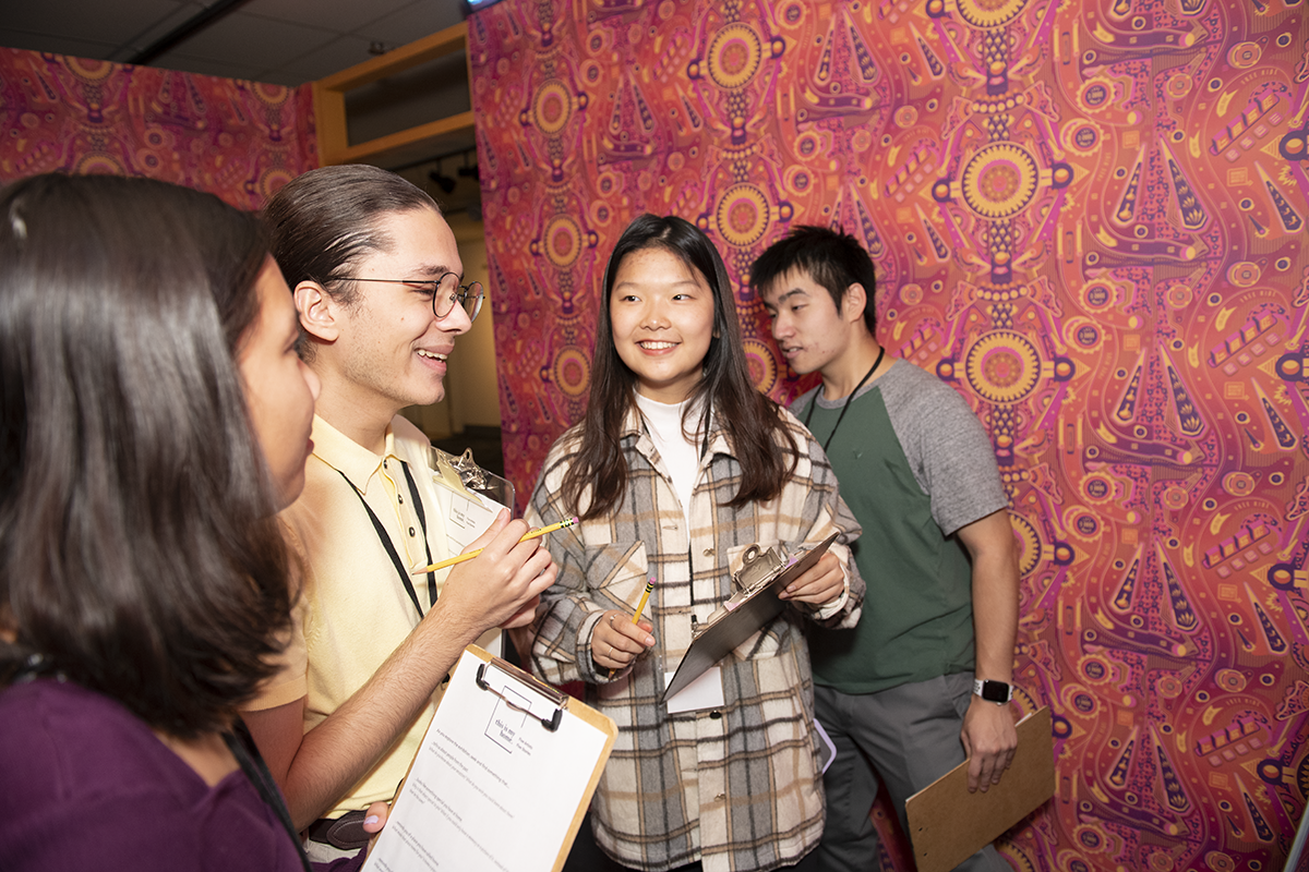 students gathered in wallpapered room