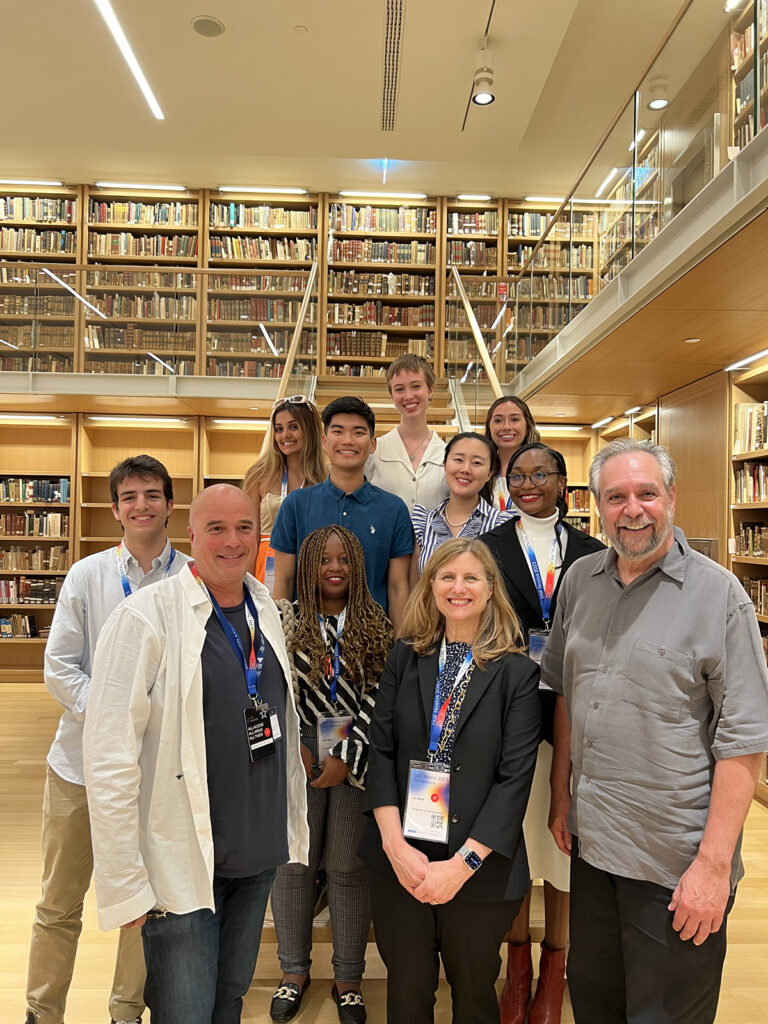 group of people standing on steps inside a library