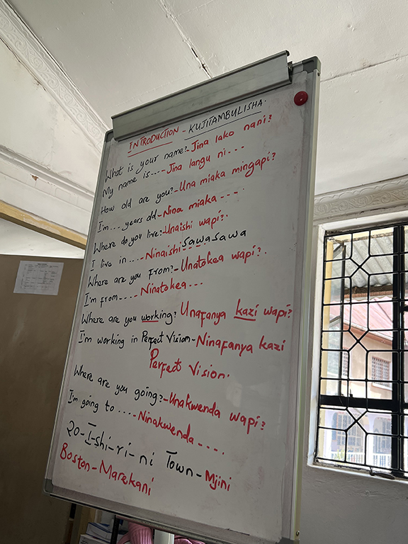 classroom board with introductory phrases in English and Swahili