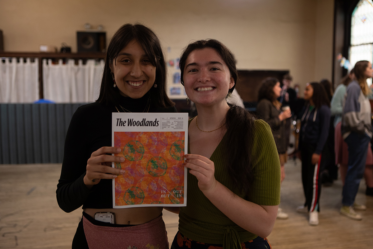two women stand side by side holding a magazine