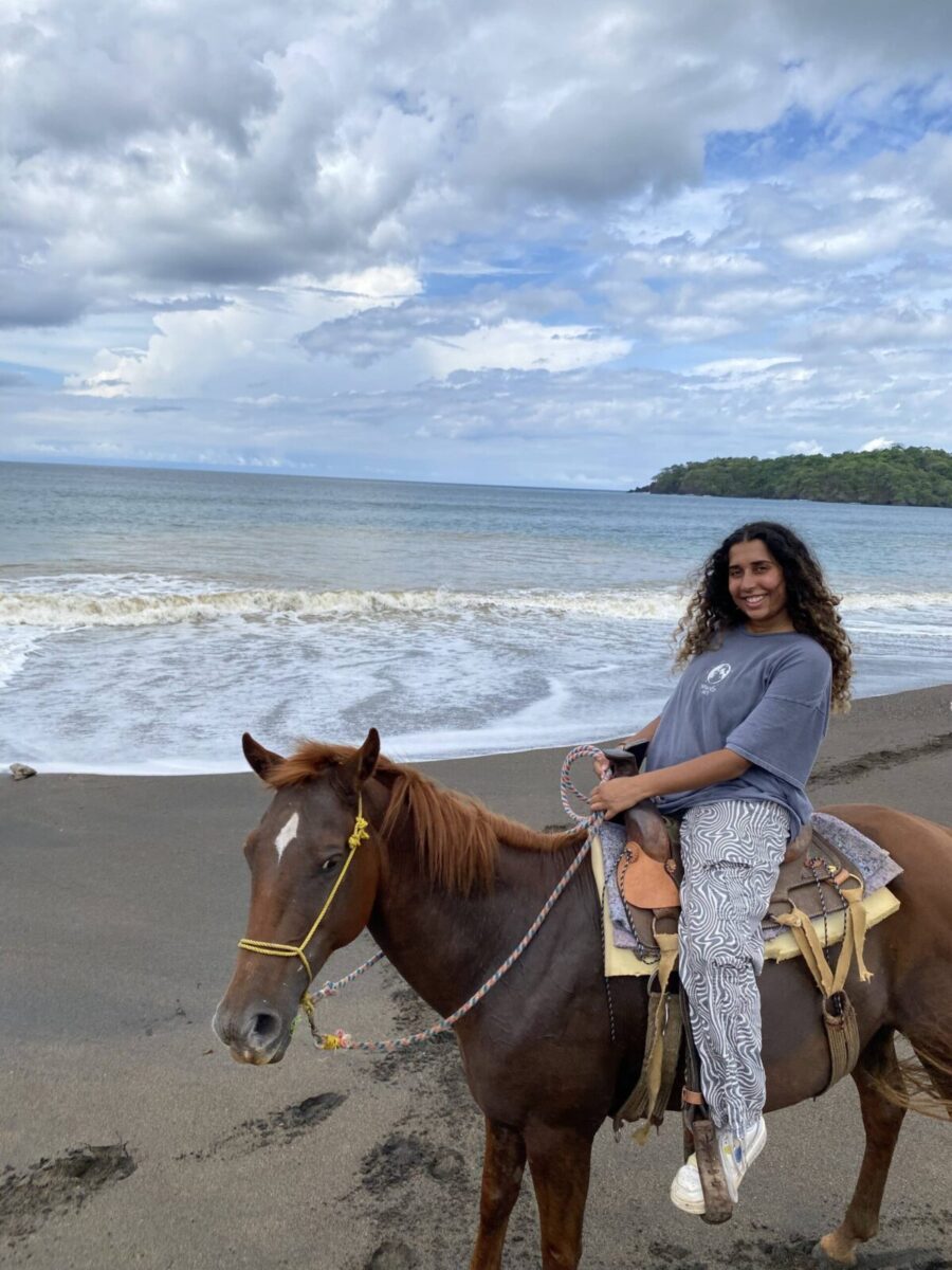 Anusha Mathur riding by horse along the ocean