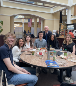 Students gathered around table with university guest for group photo on a visit to the Capitol building in Harrisburg