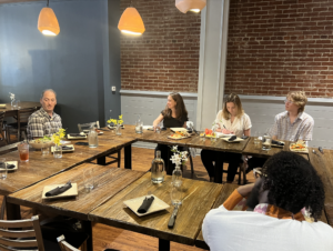 Group seated at a cafe around a table in conversation 