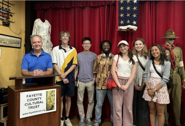 Group photo of students with director of museum smiling for camera