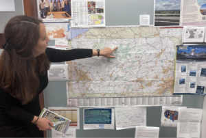 woman standing in front of map of Pennsylvania pointing to a region