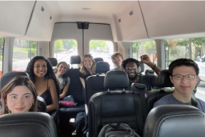 Student researchers seated in a van smiling for camera