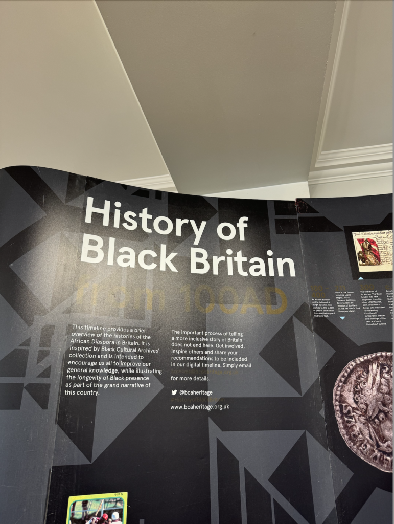 Interior view of an an exhibition and its title signage which says "History of Black Britain"