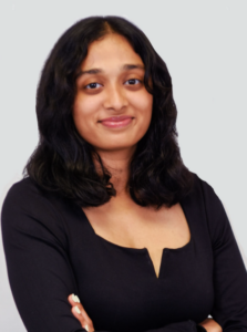 headshot of woman with long black hair wearing a long sleeve black shirt