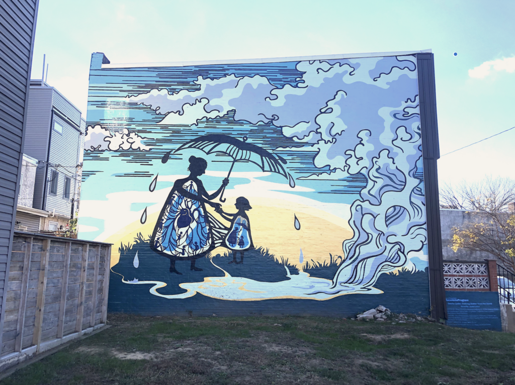 mural with woman and young child under and umbrella with a clouds and background colors of blues, grays, and yellows