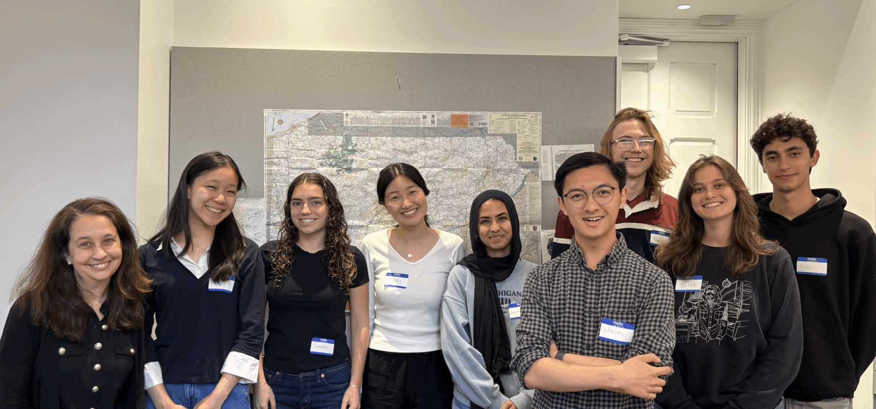 photo of a group of college students with their professor smiling for the camera