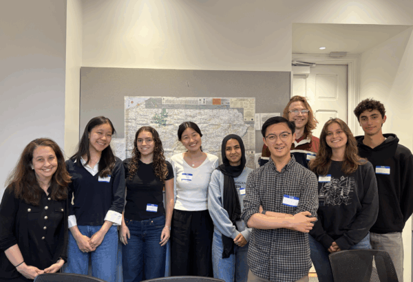 photo of a group of college students with their professor smiling for the camera