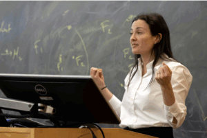 Female professor standing in front of a chalkboard teaching a lesson