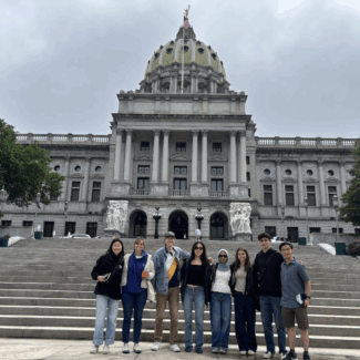 Political Empathy Lab Phase II research team in group photo standing on the steps of the state Capitol building in Harrisburg