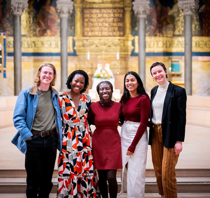 graduate students in a group photo taken at an event held in a church